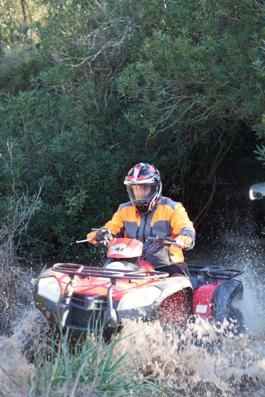 Quad che attraversa il guado sollevando spruzzi d'acqua