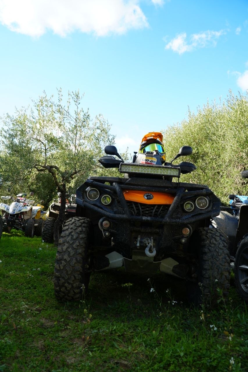 Quad Can-Am arancione con casco sul manubrio